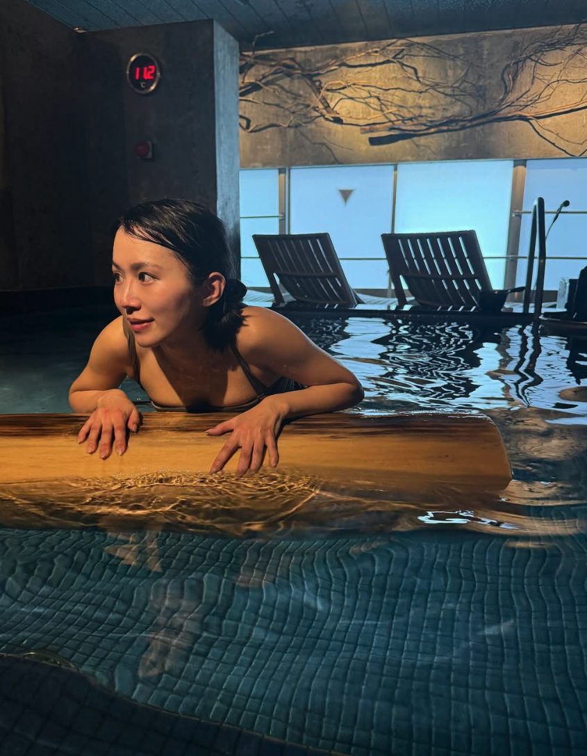 大きな水風呂のふちにもたれる女性